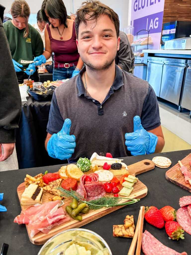 Student smiling with thumbs up behind his board.